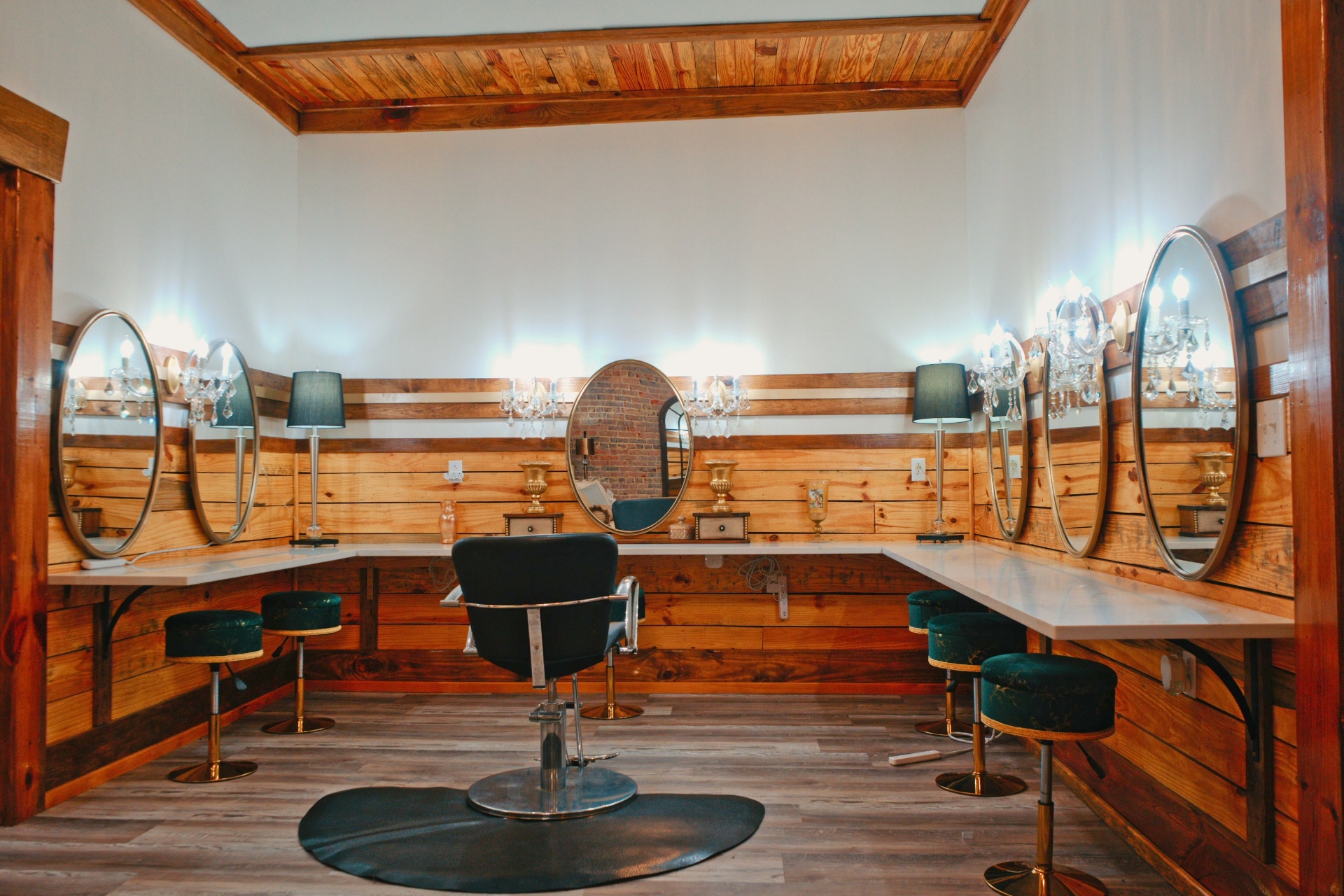 The bridal getting-ready room with wraparound vanity, oval mirrors, and emerald velvet stools